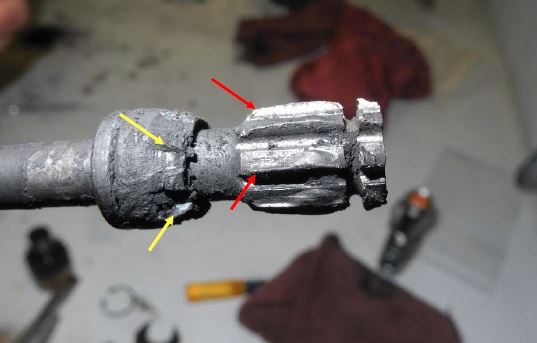 Anomalous spline damage observed on the small splines of the drive shaft (red arrows) and indentations observed on the drive shaft spacer (yellow arrows). (Credit: NTSB)