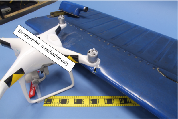 "Angled view comparing common drone to impact marks. The drone in the photo is an exemplar of a popular drone used to illustrate size comparison. Numerous manufacturers and models of drone fall into this size class. Does not necessarily depict the actual collision object "(Credit: NTSB)
