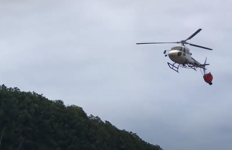 Hélilagon Airbus AS350B3e / H125 Trailing its Tangled Bambi Bucket after an Impact with its Tail Rotor while HESLO Fire-Fighting at the Piton de la Fournaise Volcano, Réunion (Credit: YouTube Video Posted by BK117)